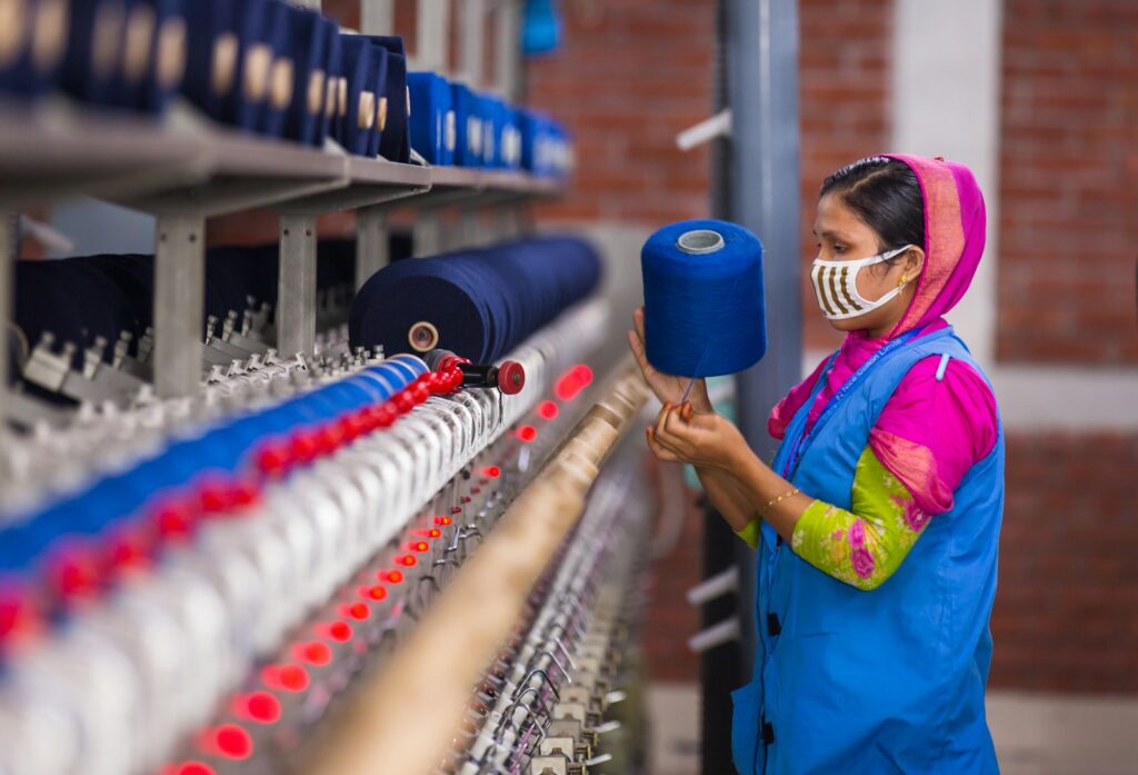 Woman working with yarn on a textile machine in Bangladesh