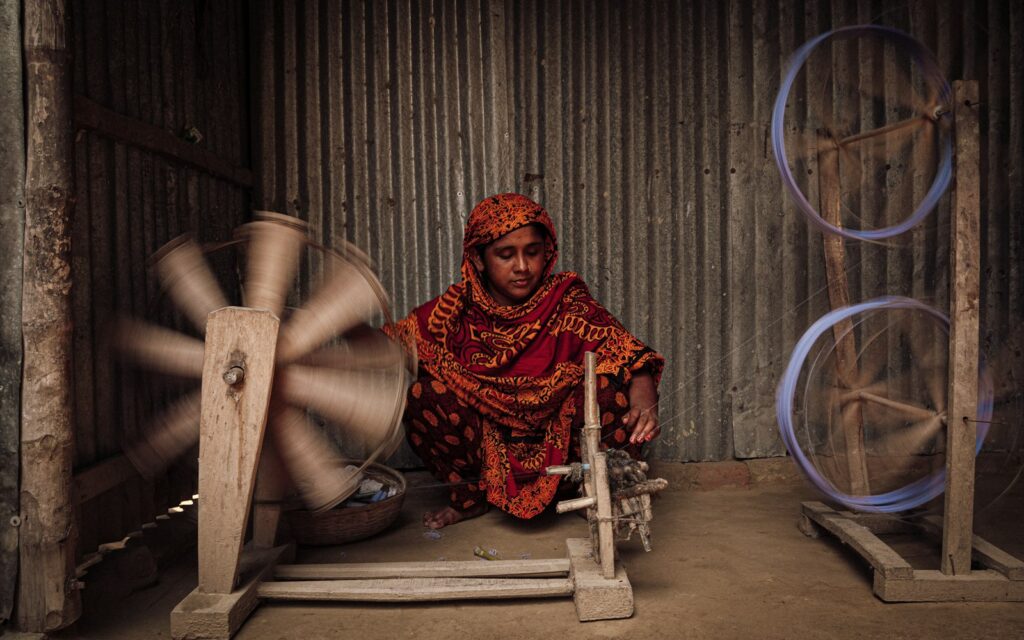 Woman working at a traditional spinning wheel